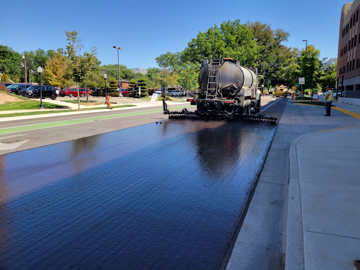 Fresh asphalt being laid on a commercial parking lot