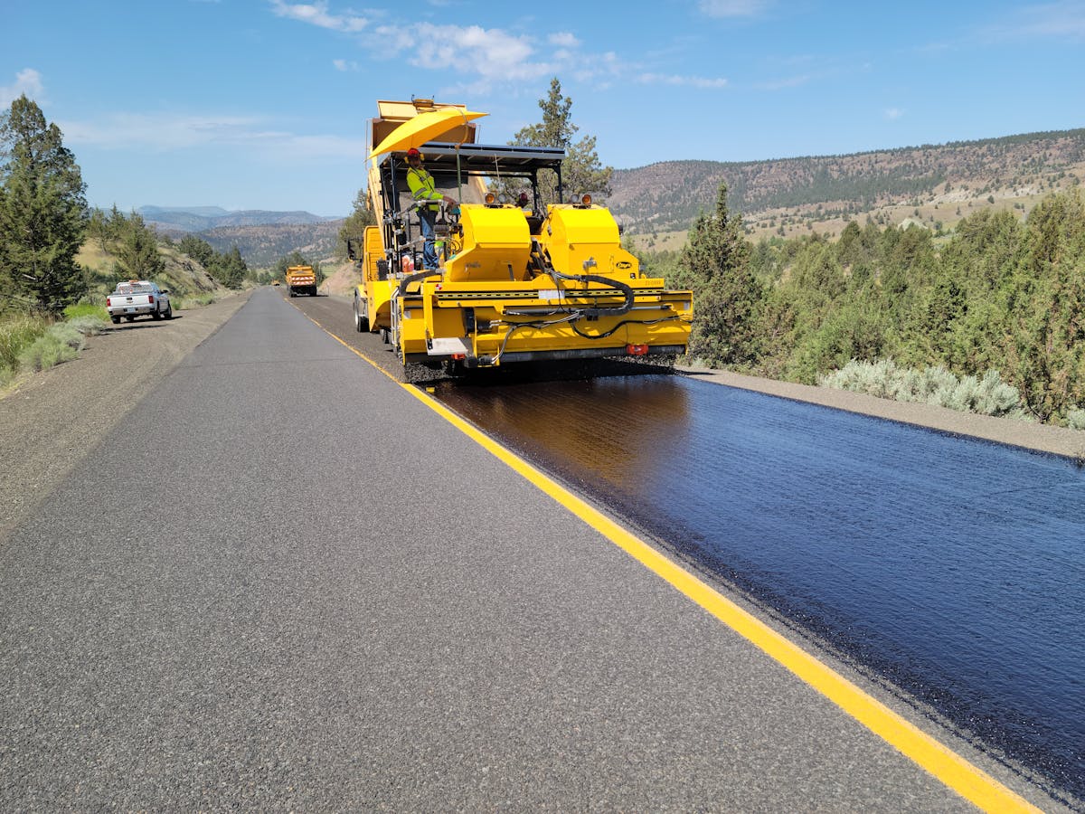 Crew sealing cracks on a commercial asphalt road surface
