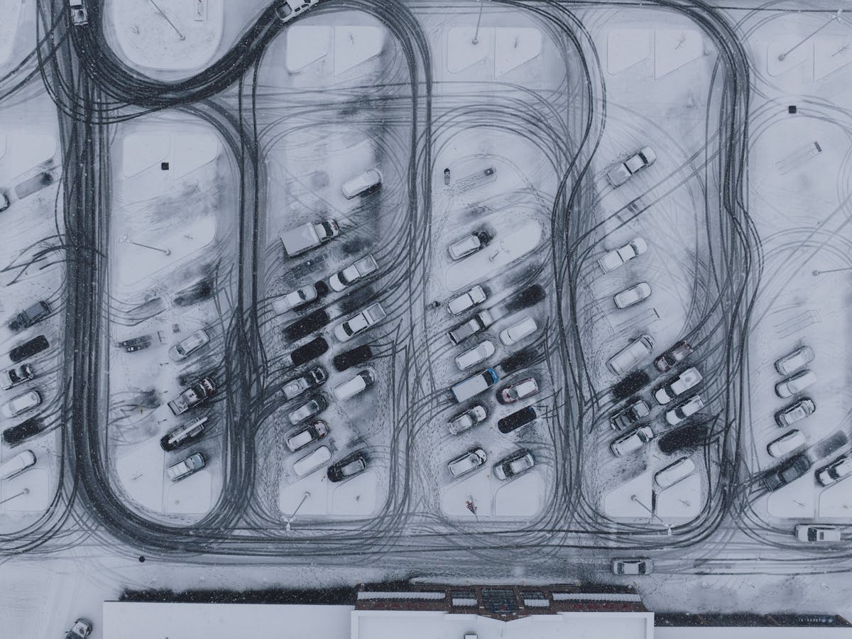Aerial view of a cleared, snow-covered commercial parking lot